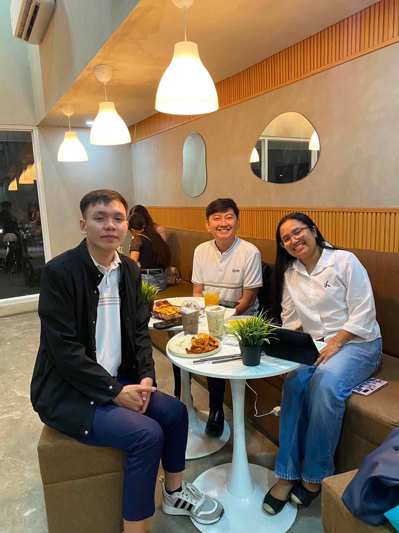 Jayson with two young professionals at a cafe during a small-group mentoring session