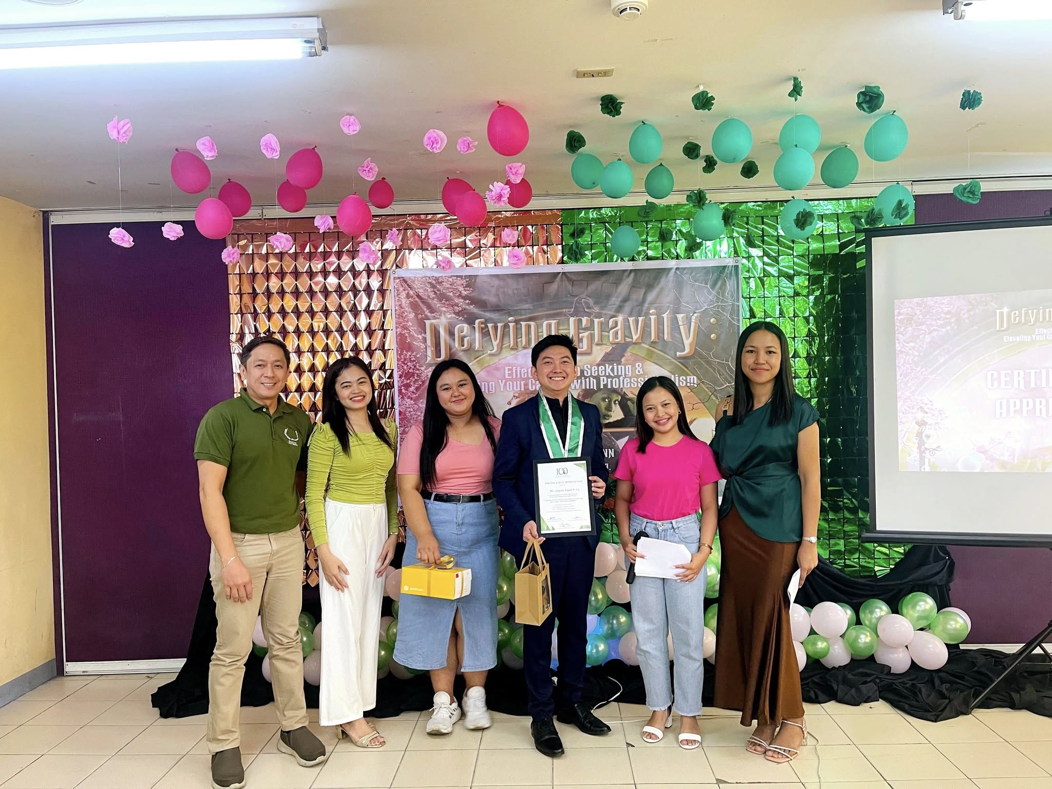 Jayson holding his certificate of appreciation with Baliuag University faculty and student organizers
