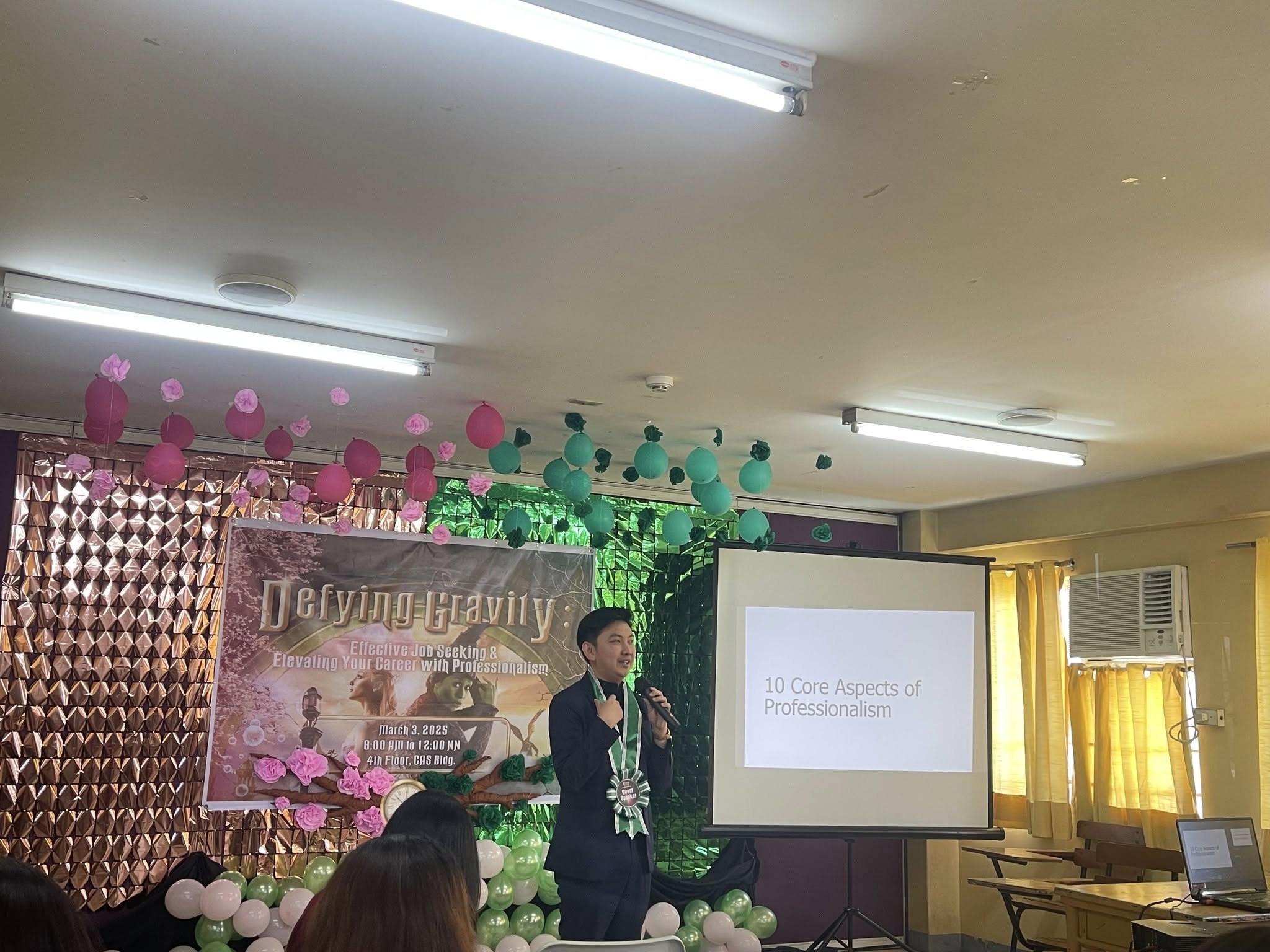 Jayson presenting the 10 Core Aspects of Professionalism in front of the Defying Gravity event banner