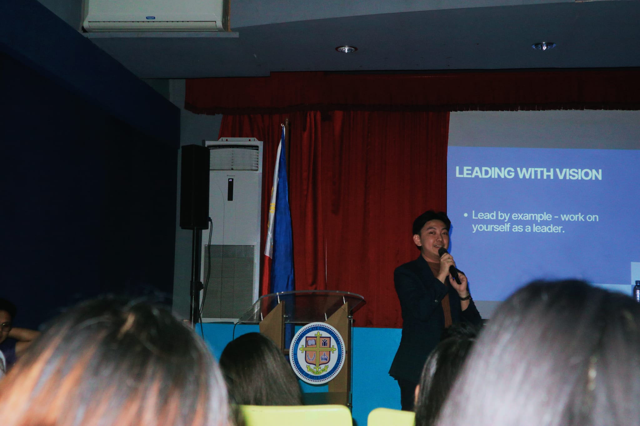Jayson delivering a Leading with Vision session beside the podium at ICI College