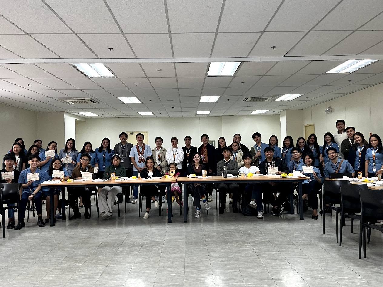 Jayson Ryan Co with National University – Baliwag entrepreneurship seminar participants holding certificates around a long table