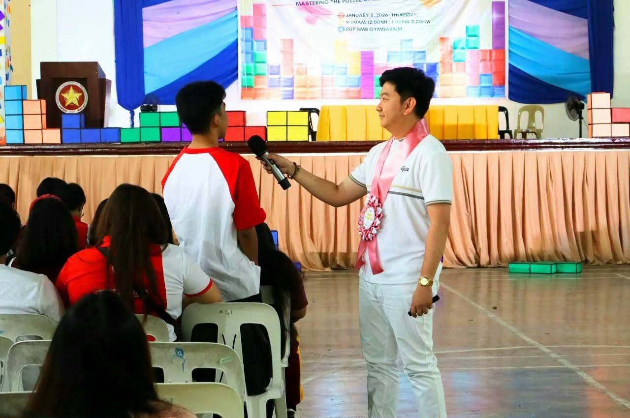 Jayson holding the microphone for a student during an open forum