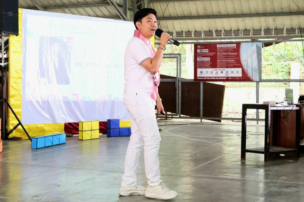 Jayson Ryan Co speaking with a microphone to BS Entrepreneurship students at PUP Sta. Maria