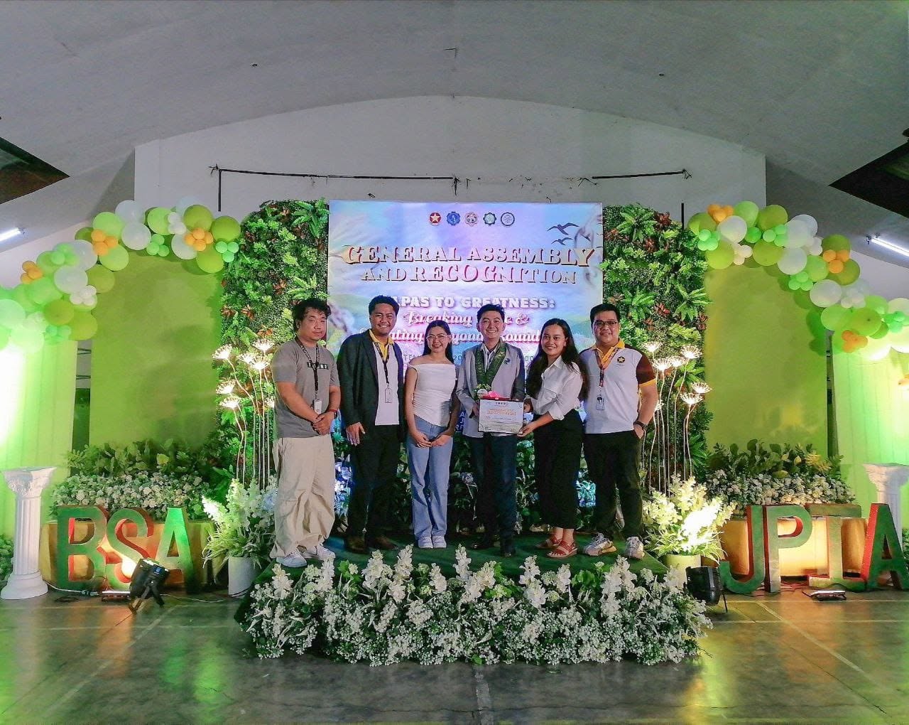 Jayson receiving a certificate of appreciation with JPIA officers and PICPA Bulacan representatives on the decorated stage
